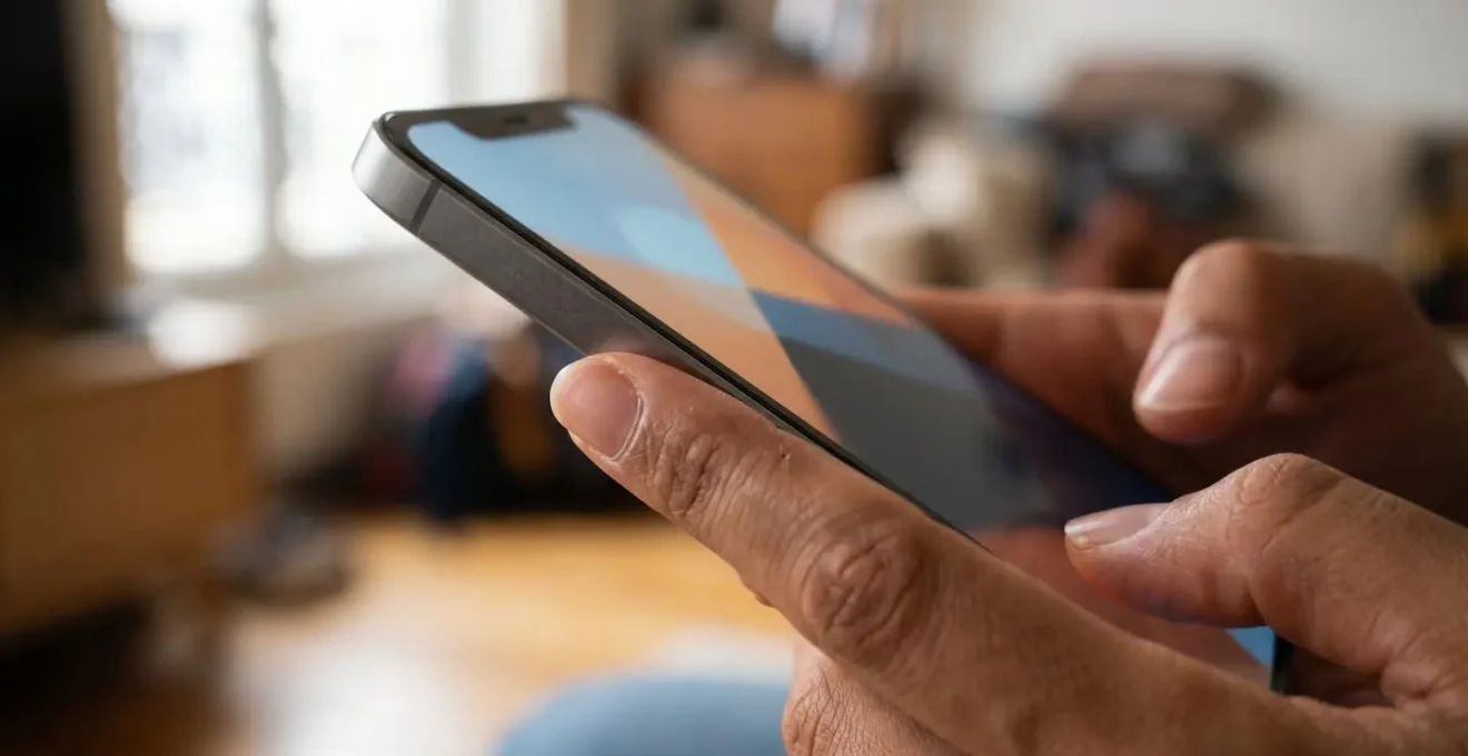 Gros plan sur des mains tenant un smartphone avec interface d'application d'assurance moderne en France